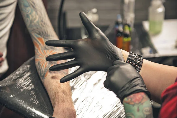 Woman arm wearing gloves before creating tattoo — Stock Photo, Image