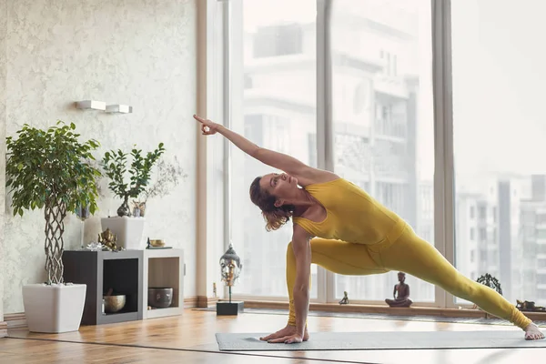 Slim yogui femenino posando en apartamento — Foto de Stock