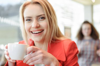 Mutlu genç kadın kafeteryada kahve içme