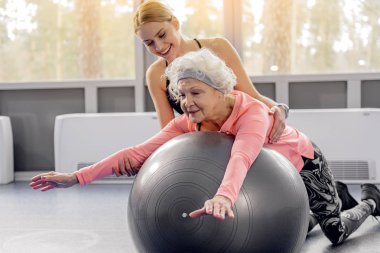 Gülümseyen emekli fitball eğilerek