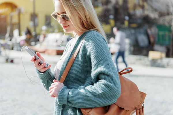 Ragazza cool utilizzando il telefono per l'intrattenimento musicale — Foto Stock