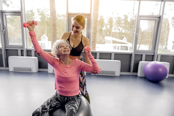 Fröhliche Rentnerin turnt im Fitnessstudio — Stockfoto
