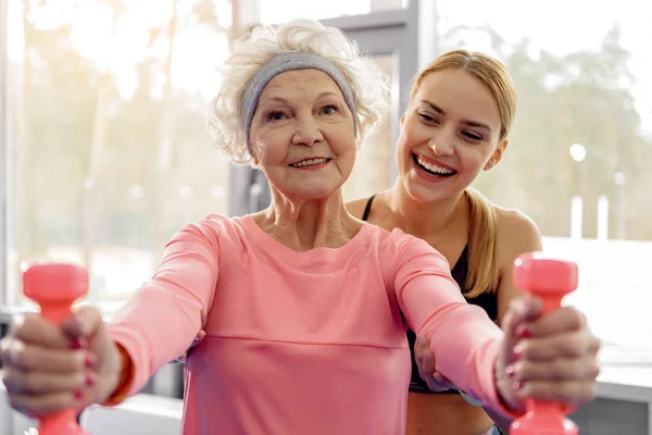 Веселая бабушка делает упражнения в спортзале — стоковое фото