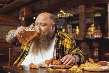 Glad obese male tasting alcohol in pub clipart