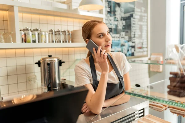 Trabajador de cafetería despreocupado hablando por teléfono inteligente — Foto de Stock