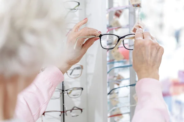 Stará žena drží rád brýle — Stock fotografie