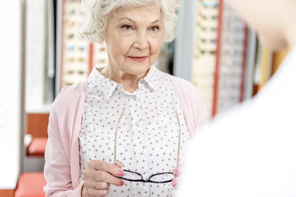 Smiling mature woman keeping eyewear — Stock Photo, Image