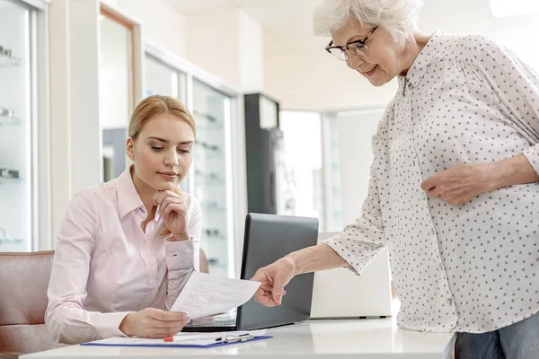 Recepcionista atento sosteniendo el papel necesario — Foto de Stock