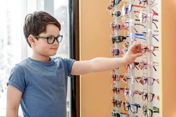 Criança do sexo masculino interessado em loja de óptica — Fotografia de Stock
