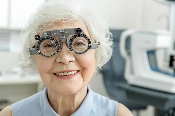 Hilarious smiling old female person checking eyesight — Stock Photo, Image