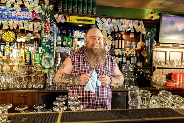 Выходящий жирный бармен, находящийся в комнате с краном — стоковое фото