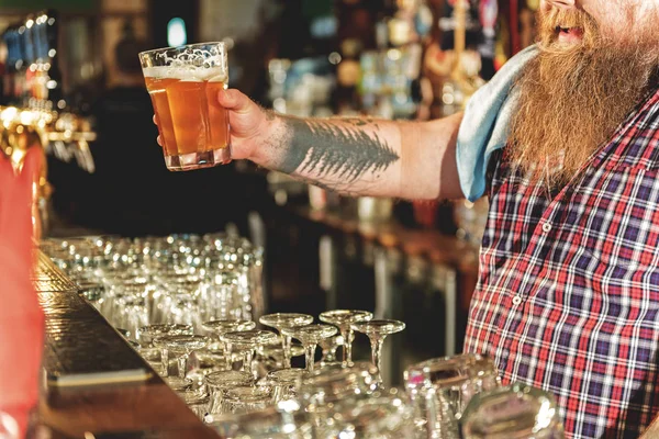 Brazo masculino estirando un vaso de cerveza —  Fotos de Stock