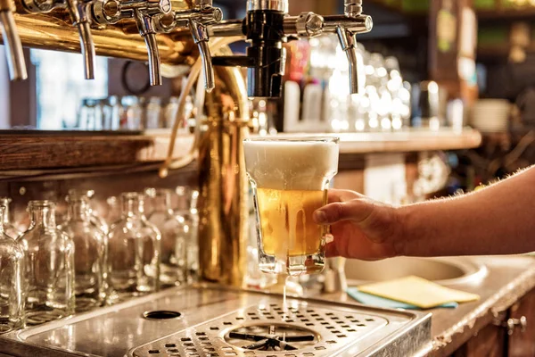 Męskie ramię utrzymanie nalewania piwa w piwiarnia — Zdjęcie stockowe