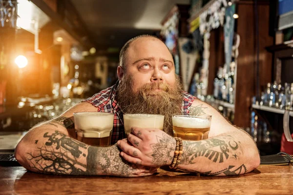 Hombre pensativo abrazando tazas de bebida alcohólica — Foto de Stock