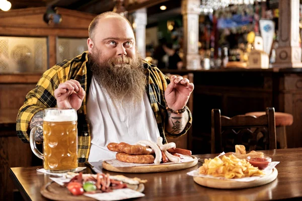 Placer hombre barbudo comiendo comida en alcohol — Foto de Stock