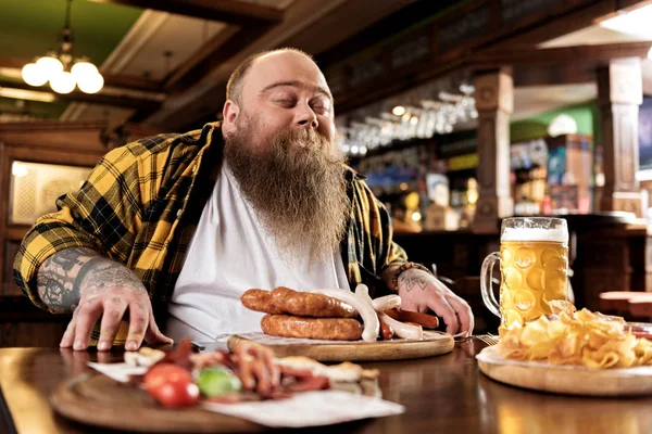 Glad fat male snuffing meal — Stock Photo, Image