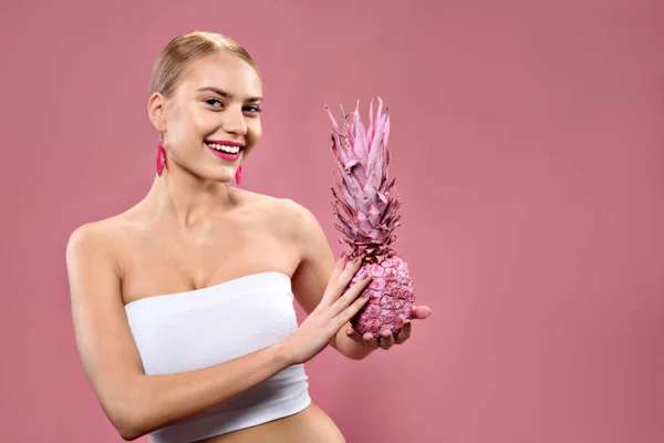 Feliz chica positiva mostrando ananas rosadas — Foto de Stock