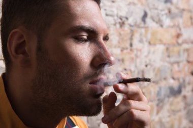 Genç melankolik exhaling sigara dumanı adam