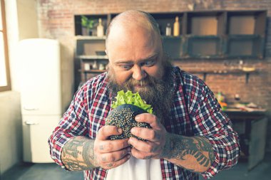 İştah sandviçi bakarak kalın adam
