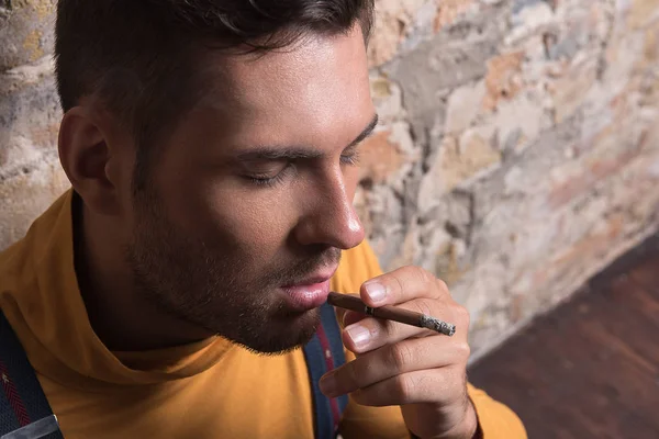 Joven ruidoso macho sosteniendo cigarrillo — Foto de Stock