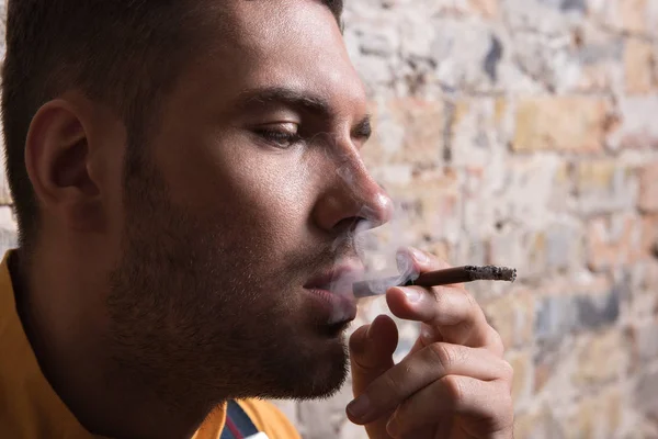 Melancholické mladý muž s úlevou cigaretového kouře — Stock fotografie