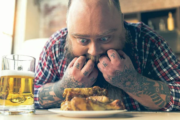 Hombre gordo mirando a la carne con apetito — Foto de Stock