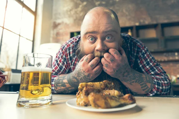 Hombre gordo hambriento está sorprendido por pollo frito — Foto de Stock