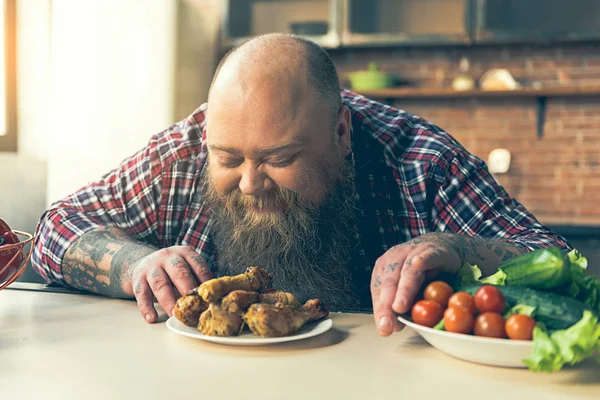 Hongerige dikke kerel ruiken vlees met plezier — Stockfoto