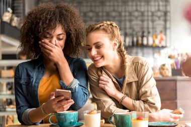 Neşeli kadınlar kafede masada konuşma