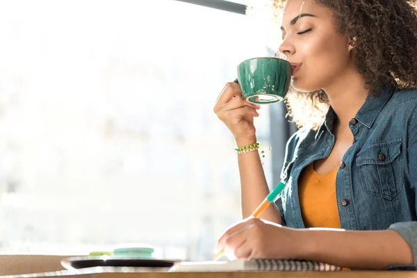 Задоволення жінка п'є каву в кафе — стокове фото