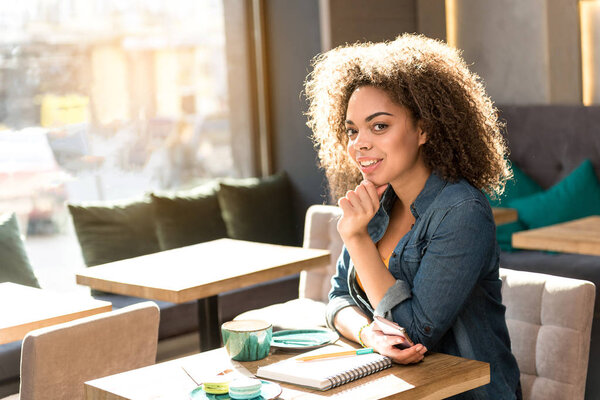 Pensive female sitting at desk in cafe