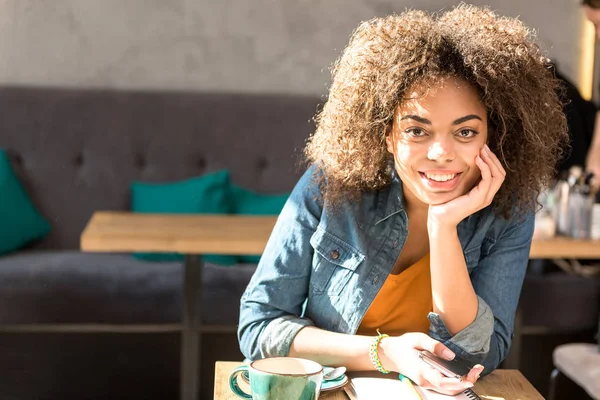 Fröhliches Mädchen am Tisch in der Cafeteria — Stockfoto