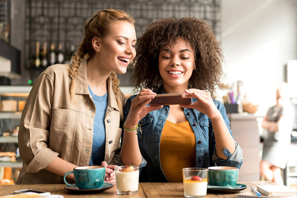 Smiling women watching at mobile