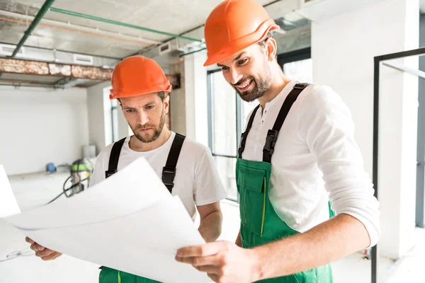 Constructeurs concentrés gardant des documents spéciaux — Photo