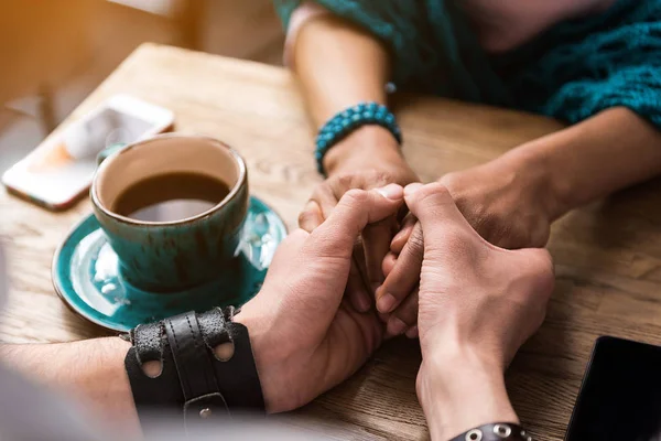 Любовники, скрепляющие руки в кафе — стоковое фото