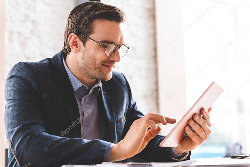 Outgoing businessman watching at digital device screen