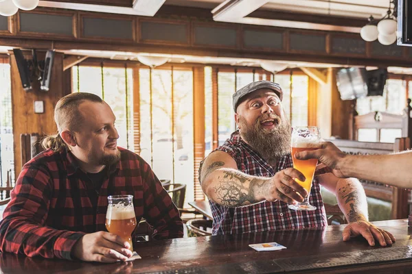 Glada män dricker lager i puben — Stockfoto