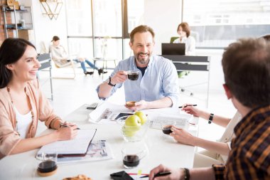 Kahve fincanı tutmak mutlu gülümseyen Yöneticisi