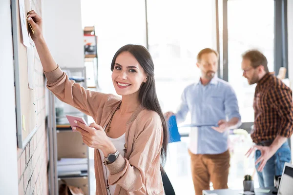 Feliz sonriente trabajadora manteniendo papel — Foto de Stock