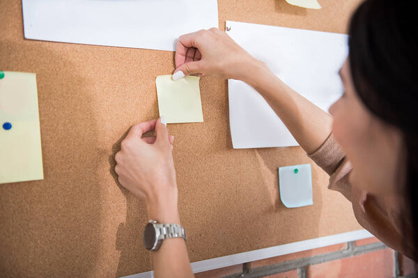 Office worker putting note on wall