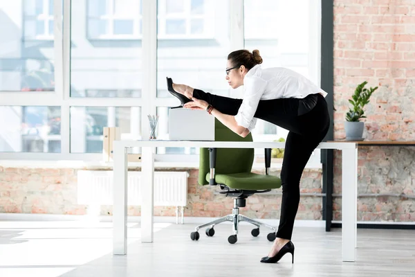 Спокойная женщина делает упражнения в офисе — стоковое фото