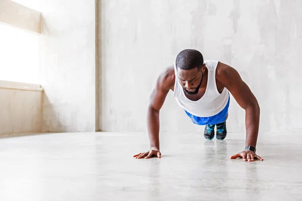 Muskulös afrikanska killen gör övningar — Stockfoto