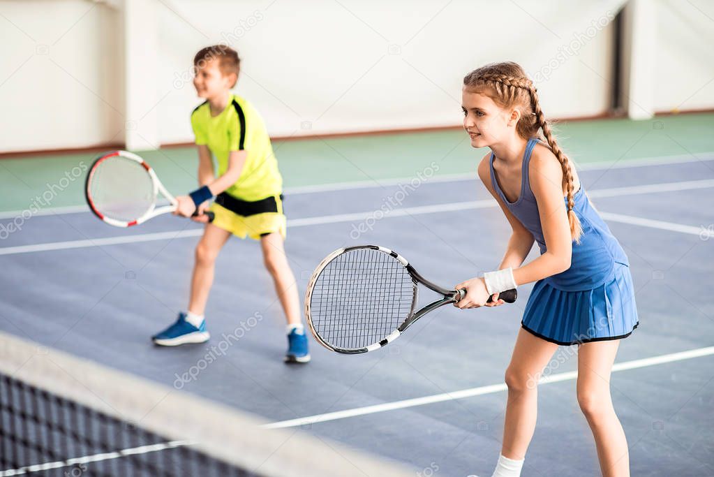 Happy children playing sport game on court