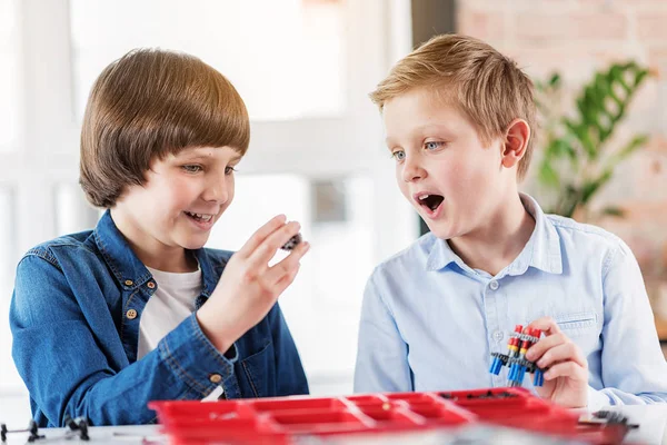 Enfants souriants intéressés tenant des pièces de rechange — Photo