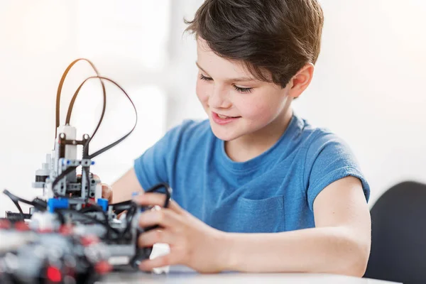 Interessato sorridente bambino maschio controllo robot — Foto Stock