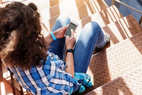 Jovem alegre com smartphone na escada — Fotografia de Stock