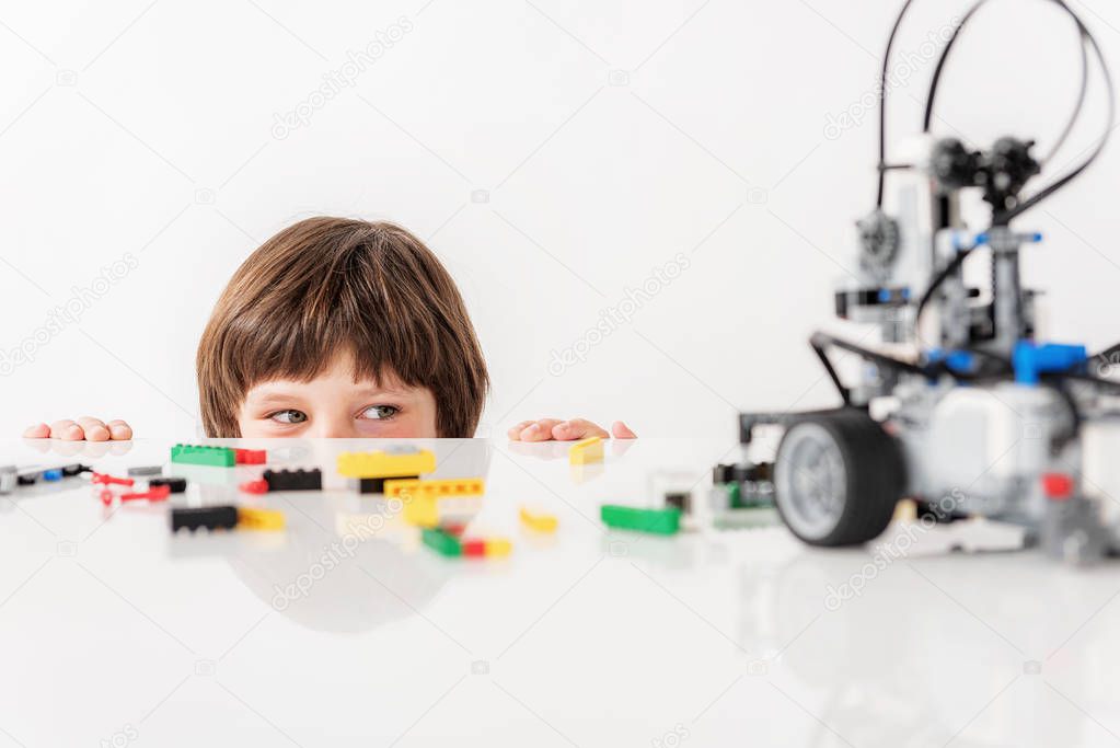 Interested sly male child glancing at toy