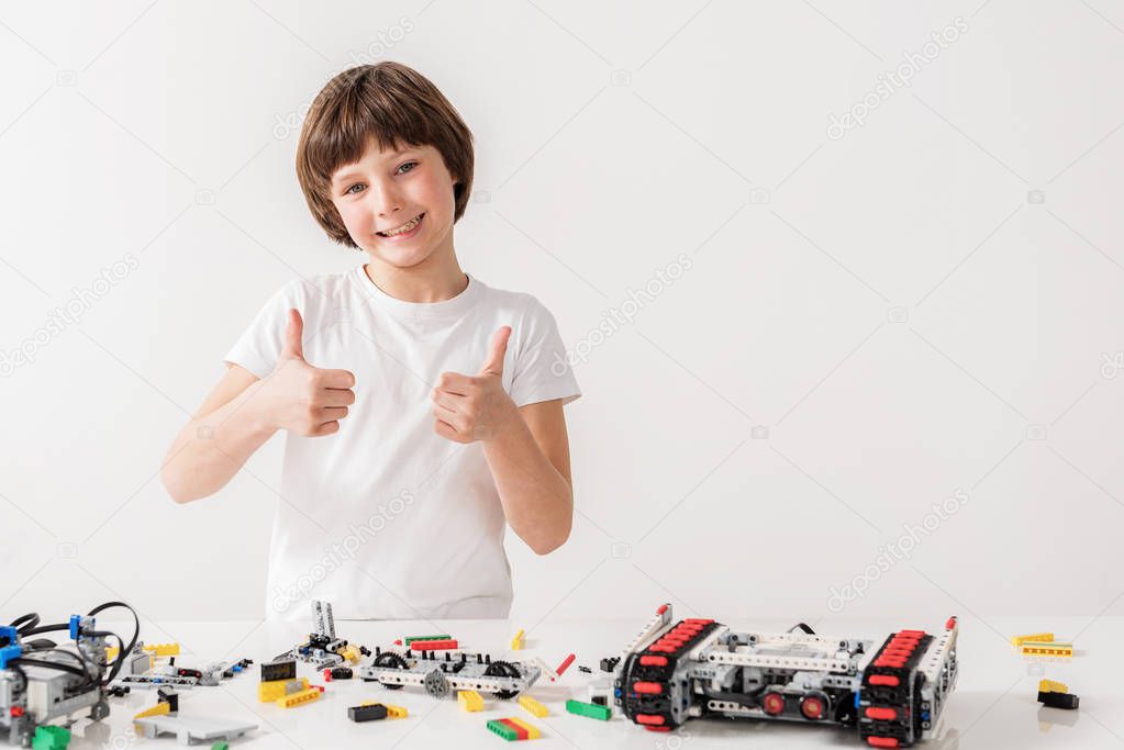 Merry smiling male kid showing ok sign