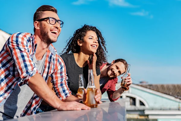 Homens e mulheres felizes desfrutando de festa no terraço do último piso — Fotografia de Stock