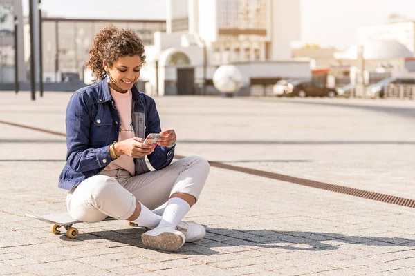 Joven mujer alegre mirando la pantalla del móvil — Foto de Stock